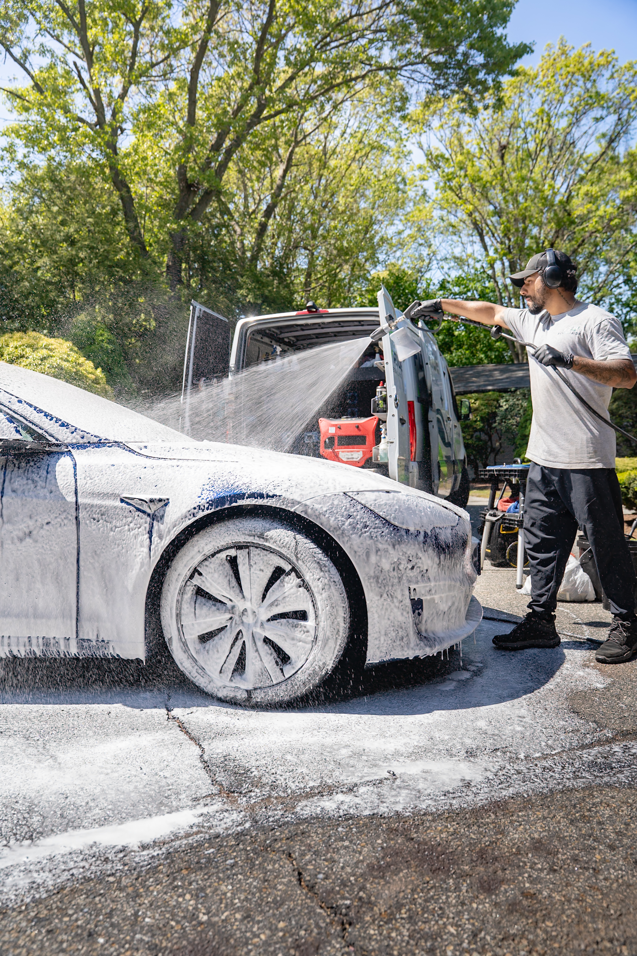 A FlyMyRide team member detailing a luxury car
